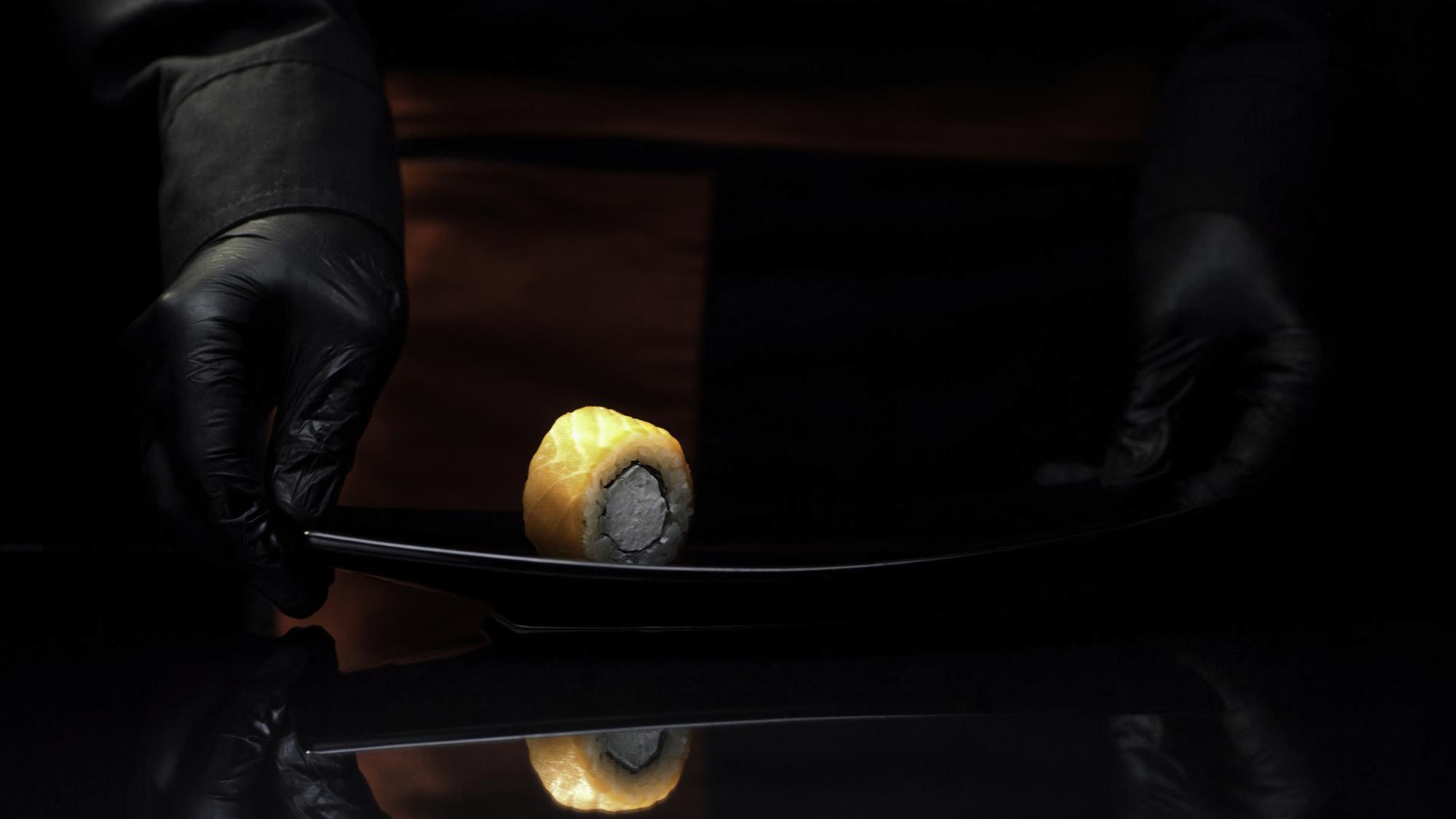 Chef plating a luxurious dish in a dark studio